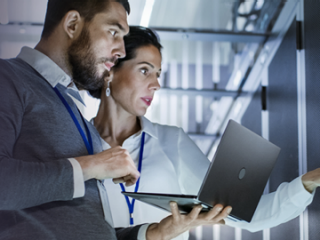 Man and woman holding a laptop