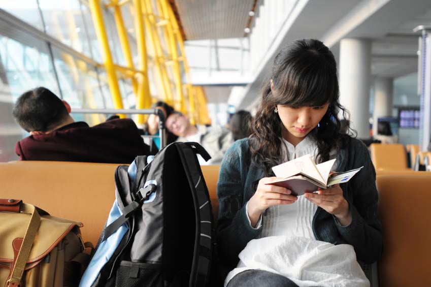 picture of a woman looking at a passport sitting at an airport gate